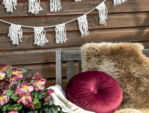 Boho garland made of macrame yarn decorated on brown wooden wall.