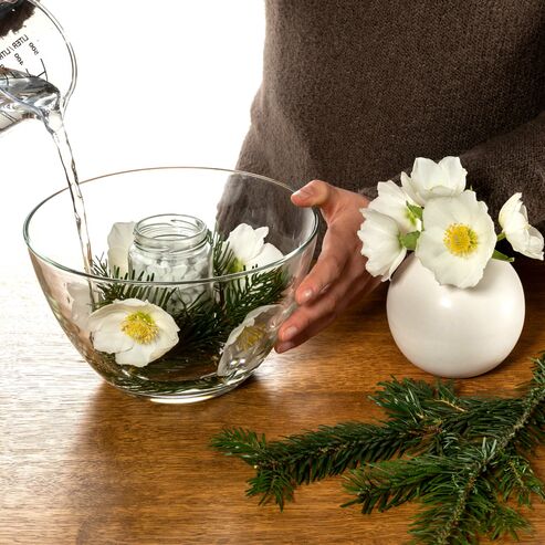 Fill the bowl with flowers and coniferous branches and pour in water carefully